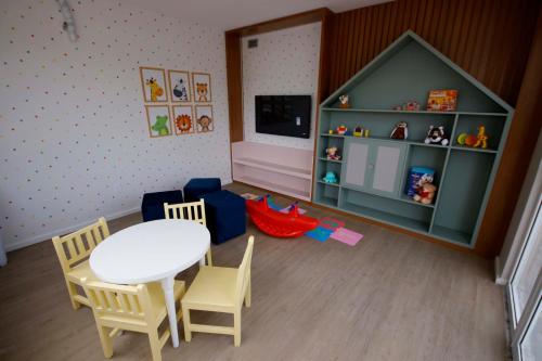 Habitación de juguete con mesa, sillas y TV en SUITE Ponta Negra, en Manaus