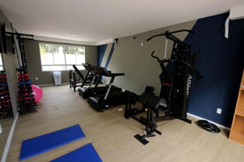 Un gimnasio con cintas de correr y bicicletas estáticas en una habitación. en SUITE Ponta Negra, en Manaus