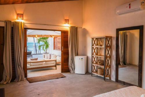 a living room with a door open to a living room at Casa Galo Pretto in Galinhos