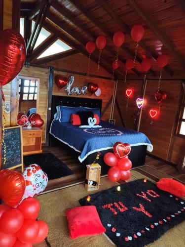a bedroom with a bed with red balloons and red accents at Glamping STELAR VILLA EL EDEN in Cali