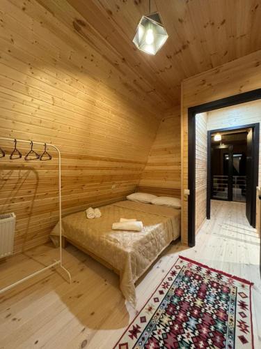 a bedroom with a bed in a wooden room at LUMA Sadgeri (Borjomi) in Borjomi