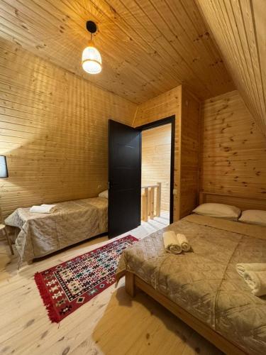 a room with two beds in a wooden cabin at LUMA Sadgeri (Borjomi) in Borjomi