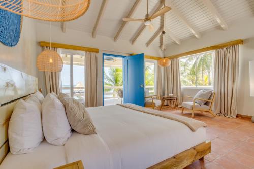 a bedroom with a large white bed in a room at Blue Reef Beach and Marina in Placencia