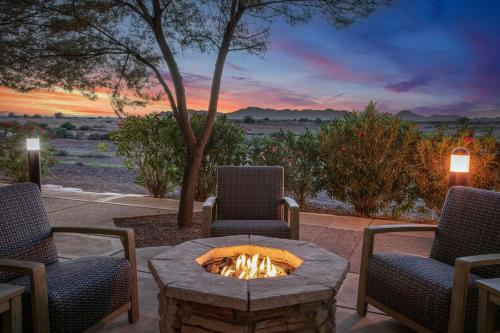 a patio with a fire pit and two chairs and a sunset at Courtyard Phoenix Chandler/Fashion Center in Chandler