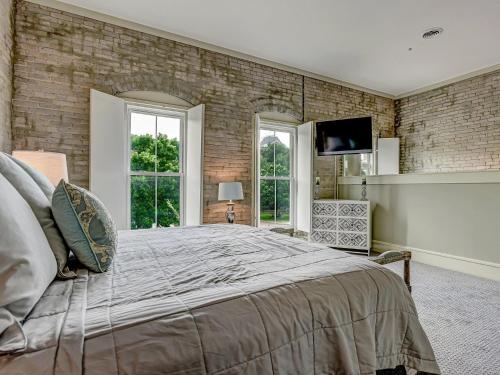 a bedroom with a large bed and a brick wall at Riverview Penthouse in Savannah