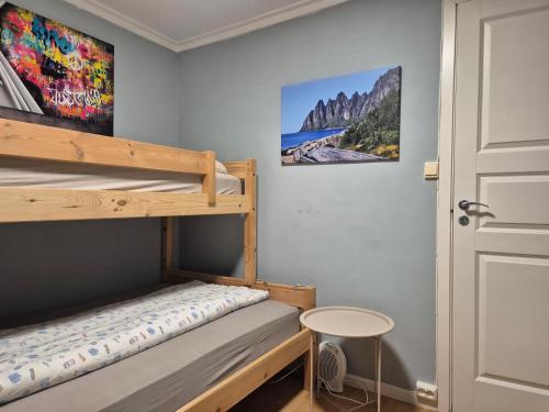 a bedroom with two bunk beds and a door at Senja 4 Summit in Torsken