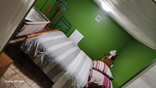 una camera da letto con una parete verde e un letto di Wauquier a Mons-en-Baroeul