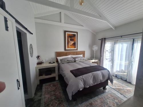 a white bedroom with a bed and a window at 66onjennings Strand in Strand