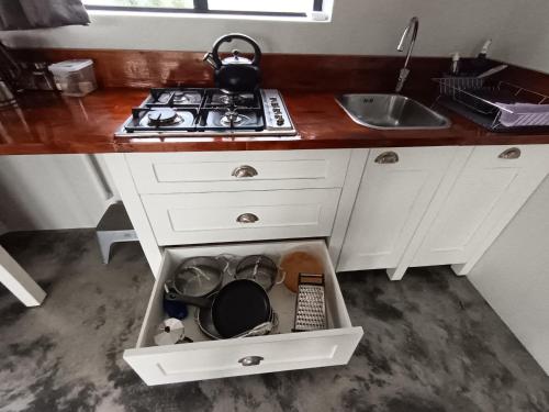 a kitchen with a sink and a stove and white cabinets at 66onjennings Strand in Strand
