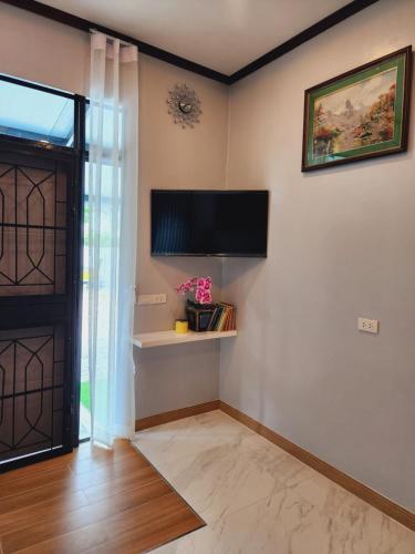 Habitación con puerta y TV en la pared en My Little House in Bangkok, en Don Muang Airport