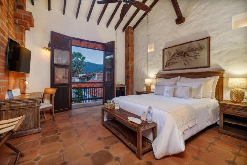 um quarto com uma cama, uma escrivaninha e uma televisão em Casa Linaje Hotel Boutique by HMC -Cauca Viejo- Mayores de 10 años em Jericó