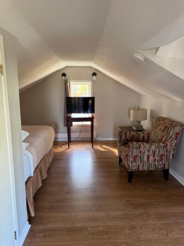 ein Schlafzimmer mit einem Bett, einem Stuhl und einem Klavier in der Unterkunft Elizabeth Ave Apartments - Loft Apartment in St. John's