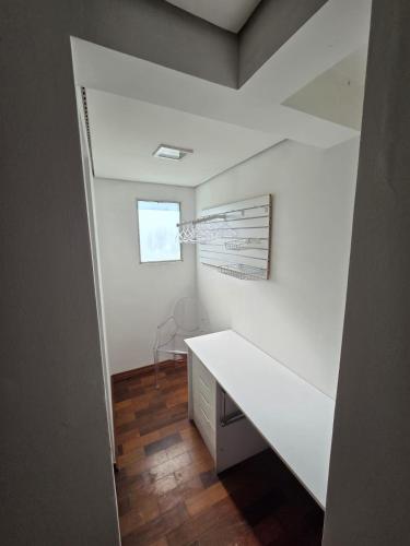 a white room with a desk and a window at Suíte privativa em casa compartilhada in São Paulo
