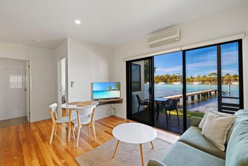 a living room with a couch and a table at Anglesea Waterfront Bungalow in Huskisson