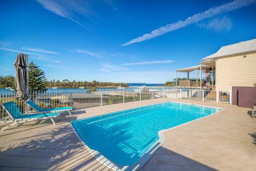 a swimming pool with a view of the water at Anglesea Waterfront Bungalow in Huskisson