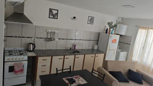 cocina con mesa, fregadero y nevera en Del Norte, en Playa Unión