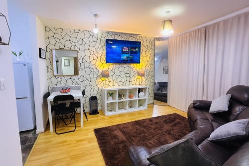 ein Wohnzimmer mit einem Sofa und einem Fernseher an der Wand in der Unterkunft Modern 2 Bed Apartment with Free Parking in Coventry