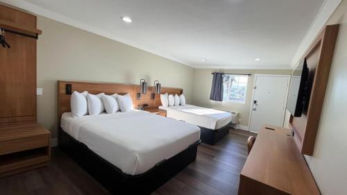 a hotel room with two beds and a television at Border Plaza Hotel in San Diego
