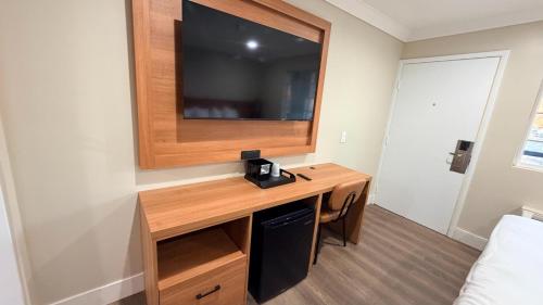 a room with a desk with a television on a wall at Border Plaza Hotel in San Diego