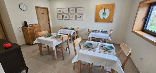una sala da pranzo con tavoli, sedie e orologio di Casa da Maragoça a Portela
