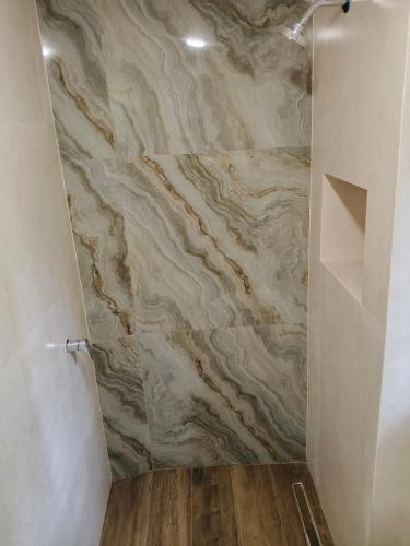 a bathroom with a shower with a stone wall at Apartamento tipo Dúplex en Sucre con garaje in Sucre