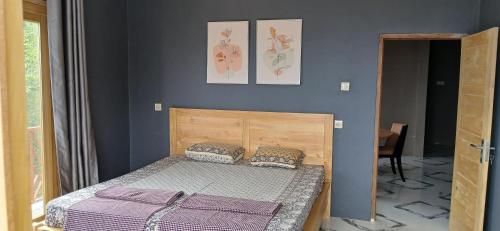 a bedroom with a bed and a blue wall at Villa Panorama Amed in Ambat