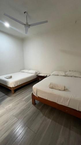 a room with two beds and a ceiling fan at Loft Guelaguetza B in Santa Cruz Huatulco