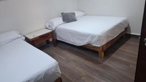 two twin beds in a room with two tables at Loft Guelaguetza B in Santa Cruz Huatulco