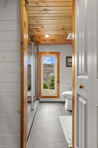 a bathroom with a toilet and a window at Ocean View Chapel Port Rexton with Sauna 2BR in Port Rexton