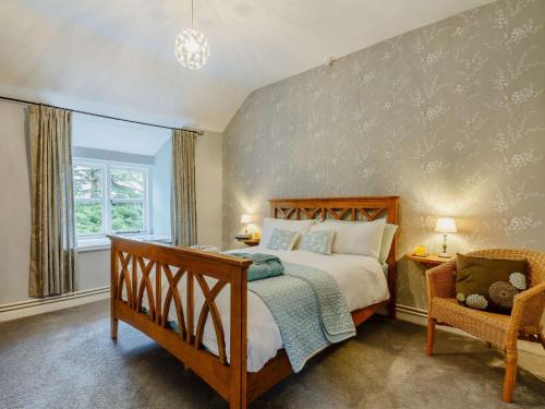 una camera da letto con un letto grande e una sedia di 4 Bed in Betws y coed 52111 a Capel Garmon