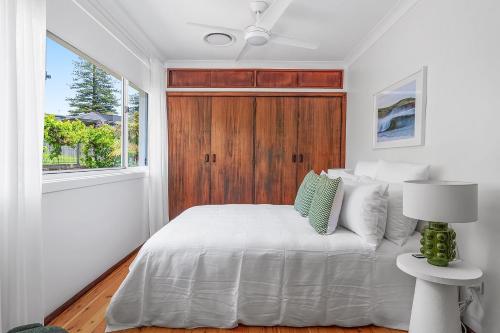 una camera da letto con un letto bianco e una finestra di Burri Burri, Gerringong a Gerringong