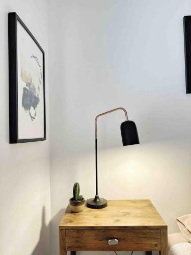 a desk with a lamp and a cactus on it at Room at the heart of the city! in Auckland