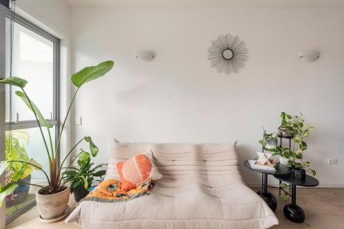 ein weißes Wohnzimmer mit Sofa und Pflanzen in der Unterkunft Stay at the heart of the city! in Auckland
