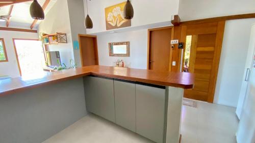 a kitchen with white walls and a wooden counter top at JanHouse Ilhabela in Ilhabela