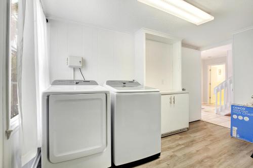 a white laundry room with a washer and dryer at The Big Tybreezy in Tybee Island