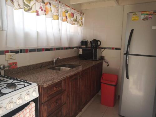 a kitchen with a sink and a stove and a refrigerator at Divina providencia in Merlo