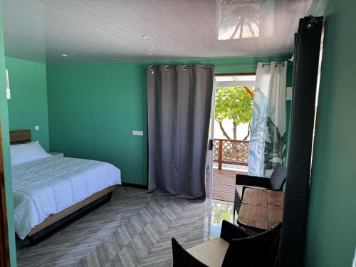 ein Schlafzimmer mit grünen Wänden, einem Bett und einem Fenster in der Unterkunft Dream lodge II in Rangiroa