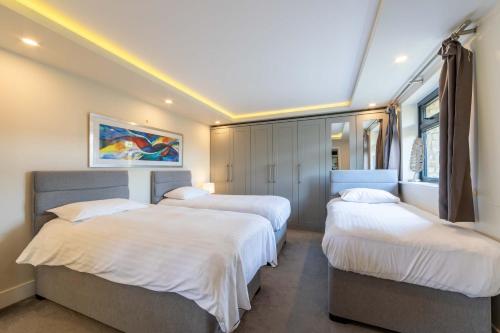 a bedroom with three beds with white sheets at lakeside Lodge in Bristol
