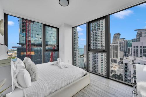 a bedroom with a bed and large windows at Miami City Lights 2BR 2BA in Miami