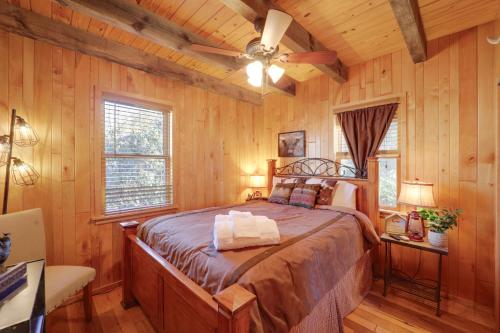 ein Schlafzimmer mit einem Bett in einem Zimmer mit Holzwänden in der Unterkunft Less Than 1 Mi to Linville Falls Family Gem with Game Room! in Linville Falls