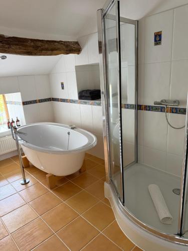 a bathroom with a tub and a shower at Grains Barn Farm in Burnley