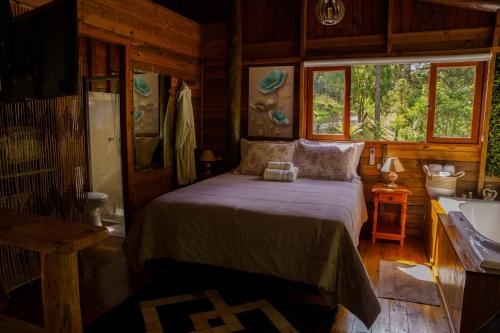 Rio FortunaにあるMaravilhoso Chalé em Urubiciの丸太小屋のベッドのある寝室