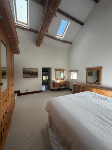 a large bedroom with a large bed and a desk at Grains Barn Farm in Burnley