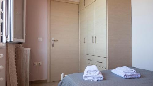 a bedroom with a bed with towels on it at Nias Beachfront Apartments close by to Sidari in Karousádes
