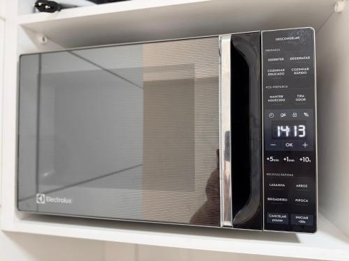 um micro-ondas com a porta aberta numa prateleira em Casa azul - próx de Nazaré com Split e Wi-Fi em Belém