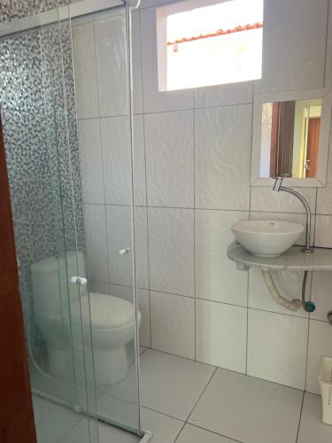 een badkamer met een douche, een toilet en een wastafel bij Aconchego Paracuru in Paracuru