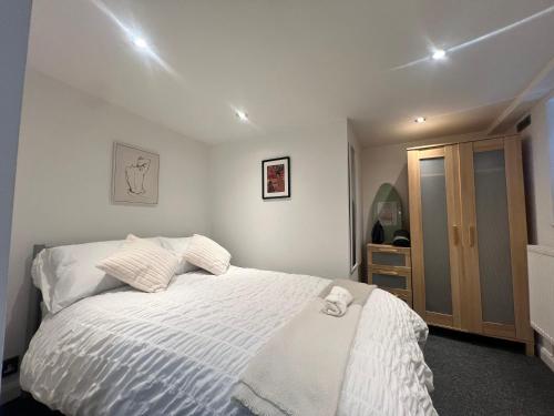 a bedroom with a bed with a white comforter at The Bluebird Rooms I in Headingley
