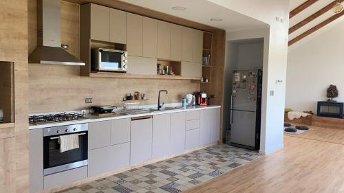 LeñaduraHermosa Casa con vista al Estrecho de Magallanes的配有白色橱柜和不锈钢冰箱的厨房