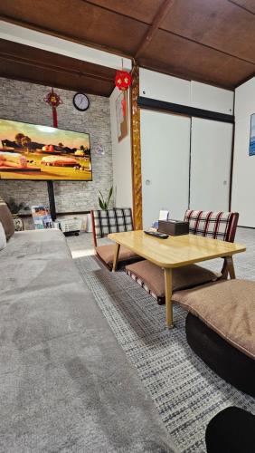 un soggiorno con tavolo e sedie in legno di YAHouse a Chiba