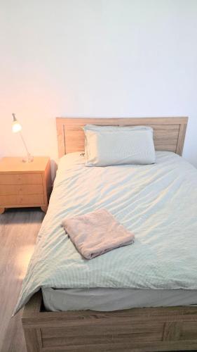 a bed with a towel sitting on top of it at Cozy Room near airport and train station in Perth